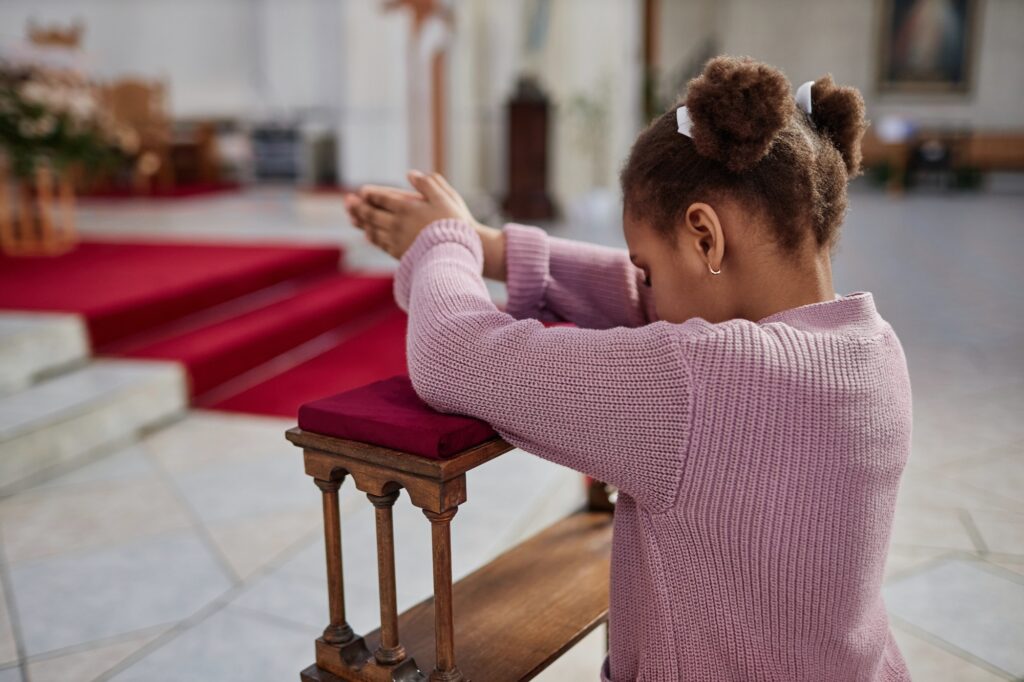 African American little girl praying in church