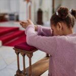 African American little girl praying in church