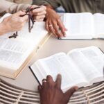 Bible, prayer group and people hands for religion support, faith and christian worship or spiritual