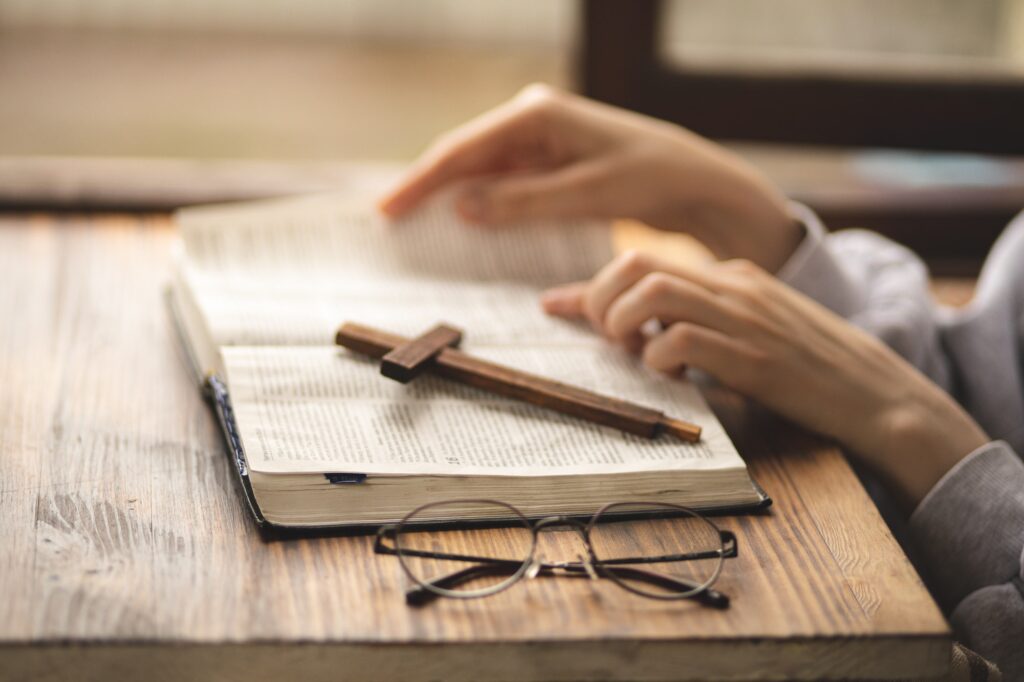 Close-up of hands on the Bible. Bible study. Prayer. Faith and religion. Believer. Praying.