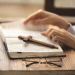 Close-up of hands on the Bible. Bible study. Prayer. Faith and religion. Believer. Praying.