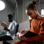 Little girl reading Bible in church